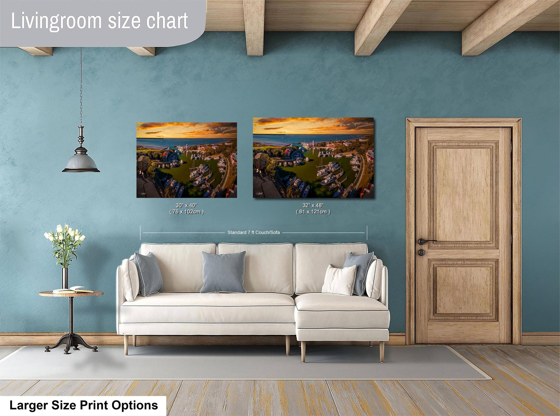 a living room with a white sofa, a wooden door, and two framed landscape photographs hanging on the wall.