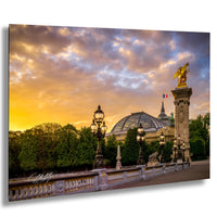 a grand, ornate building with a golden eagle statue atop a tall column, set against a vibrant sunset sky.