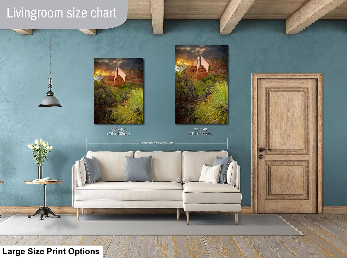 a living room with a white sofa, a wooden door, and two framed landscape paintings hanging on the wall.