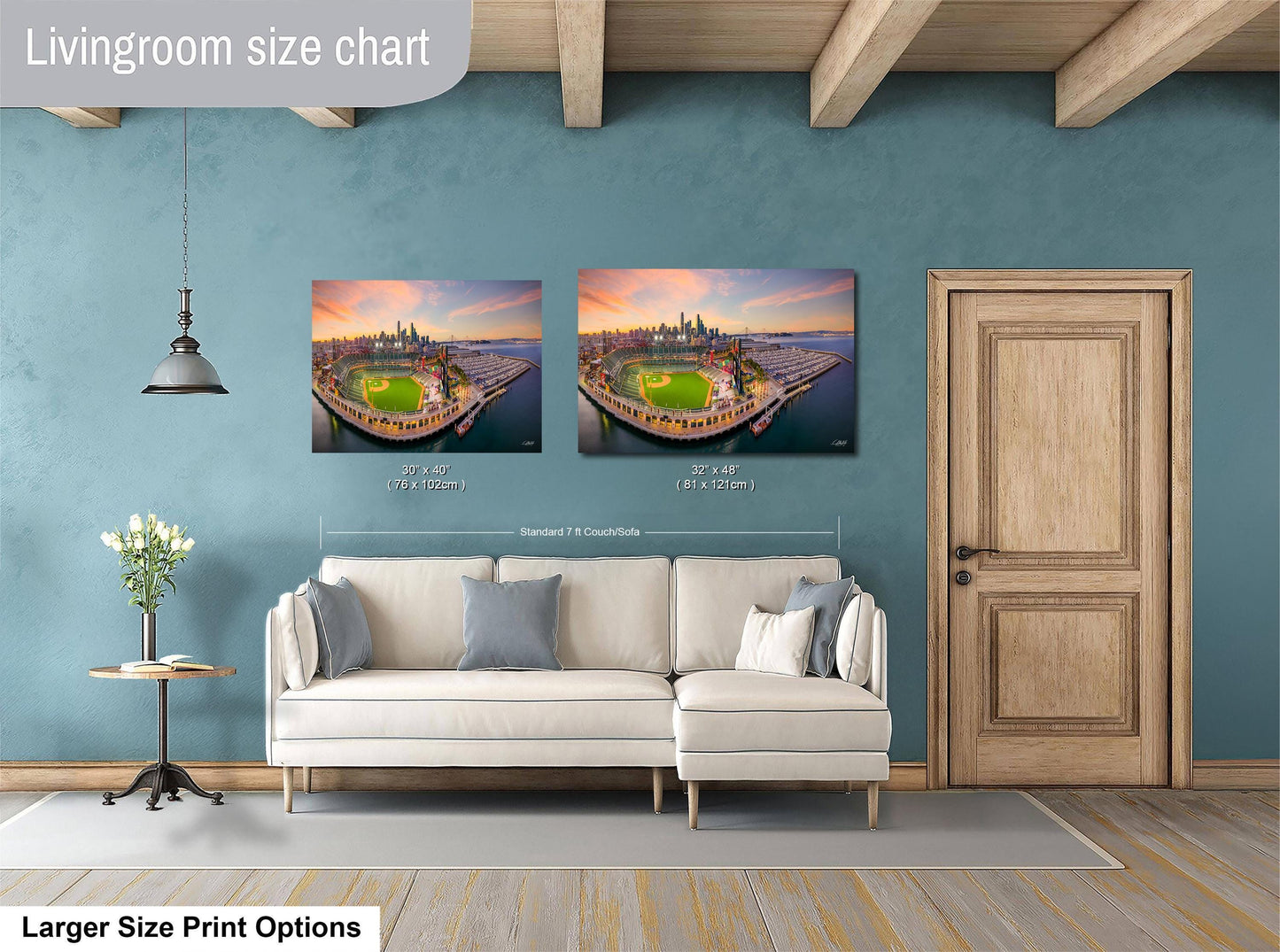 a living room with a white sofa and a wooden door. Above the sofa, there are two framed pictures of a cityscape, and the wall has a blue color. The living room appears to be well-lit and decorated.