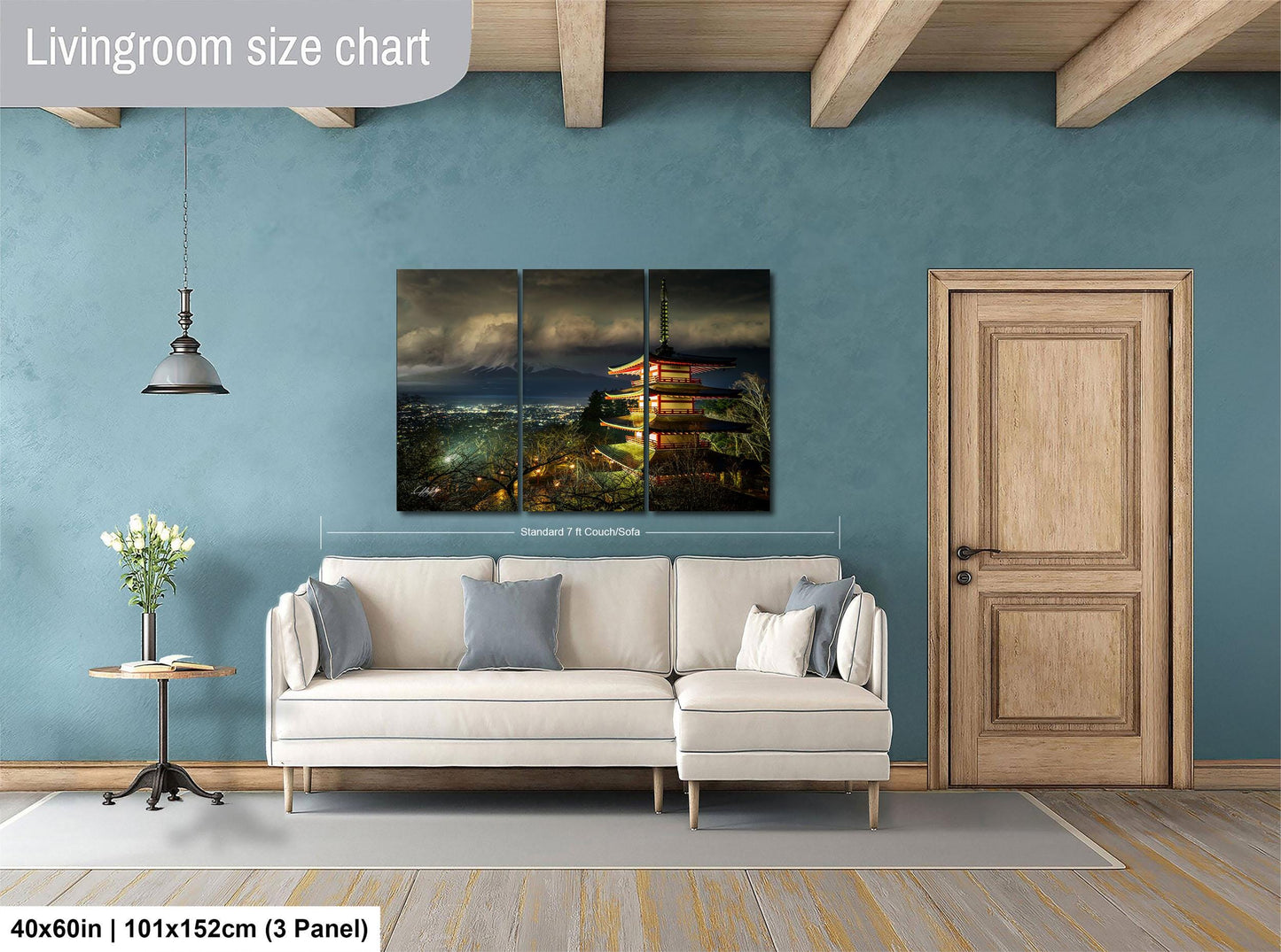 The image is a living room with a large painting of a temple in the background, a white sofa, a wooden door, and a small table with a vase of flowers.