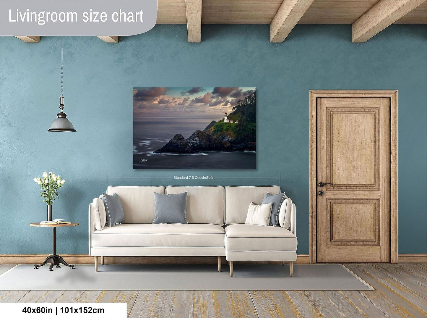 a living room with a large painting of a coastal landscape hanging on the wall. The painting is framed and measures approximately 40 inches by 101.5 centimeters. The room has a white sofa and a wooden door, creating a cozy and inviting atmosphere.