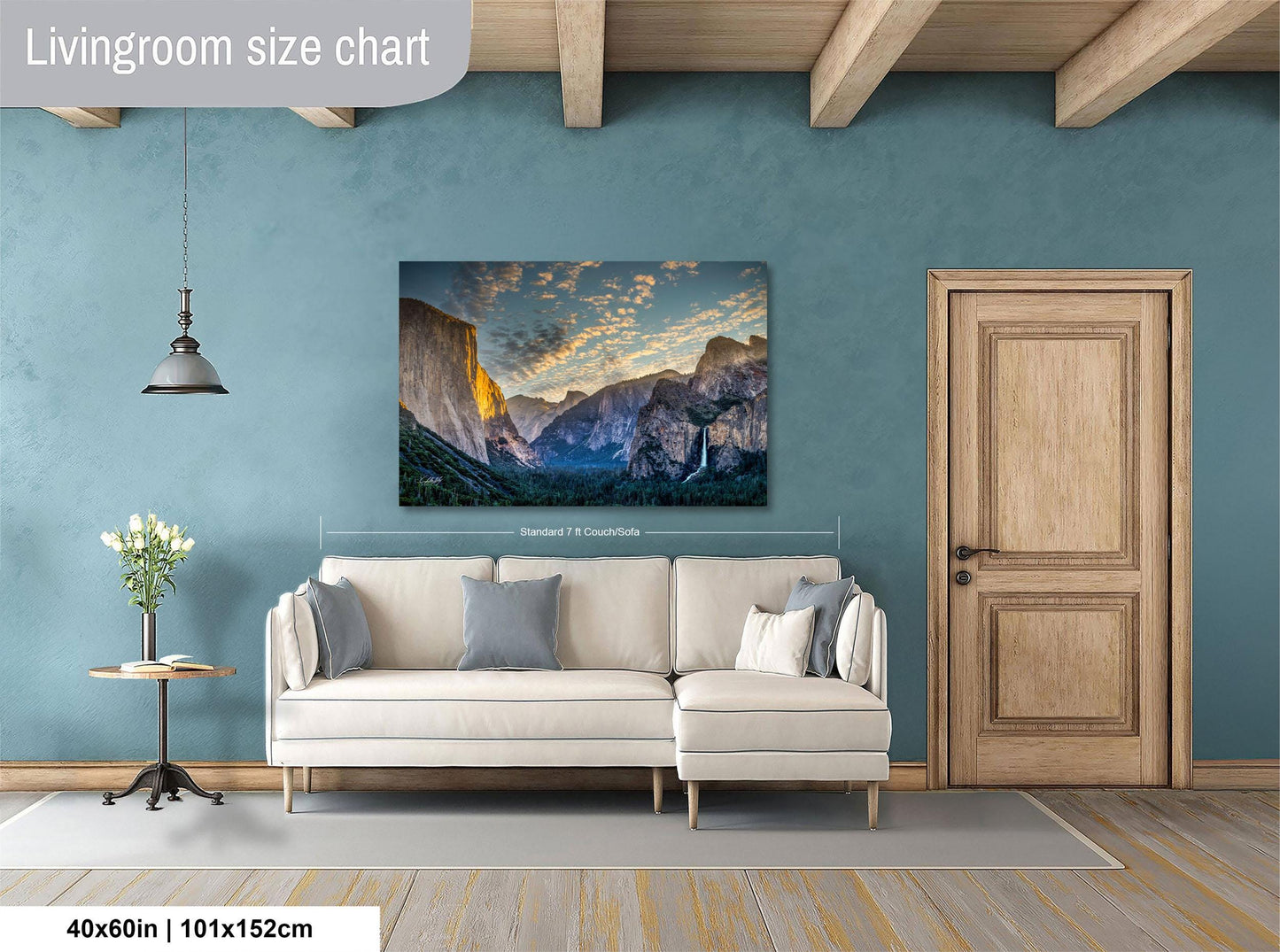 a living room with a large, framed landscape painting hanging on the wall above a white sofa.
