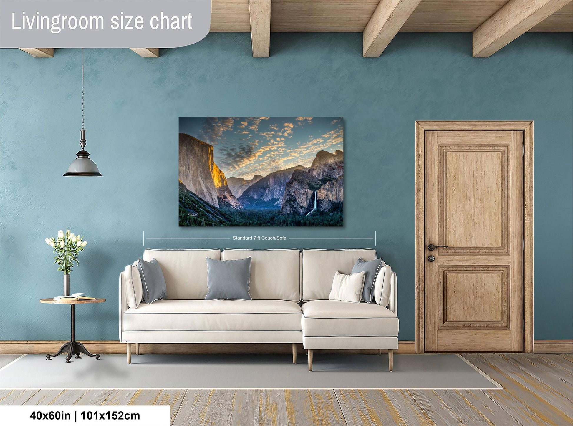 a living room with a large, framed landscape painting hanging on the wall above a white sofa.