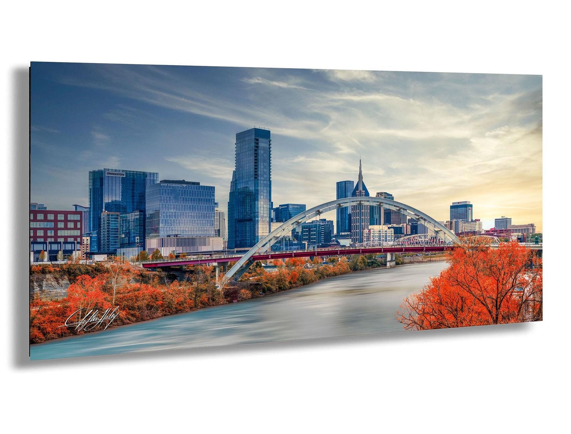 a cityscape with a large bridge spanning across a river, surrounded by tall buildings and a cloudy sky.