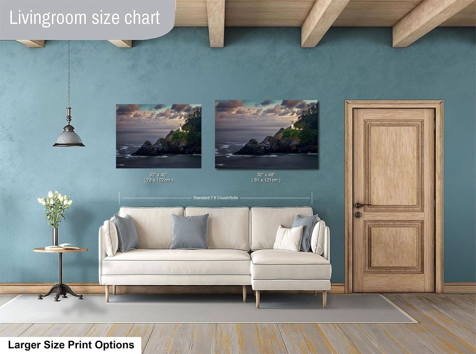 a living room with a white sofa, a wooden door, and a painting of a coastal landscape above the sofa.
