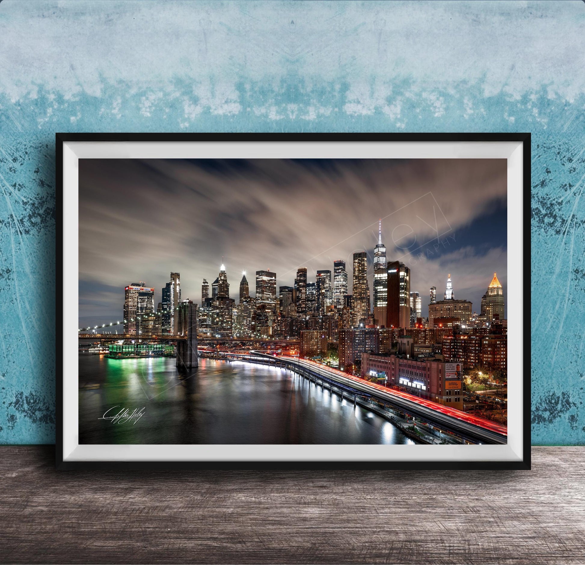 A framed photograph of the New York City skyline at night, with the city's iconic landmarks and buildings illuminated against a dark sky.