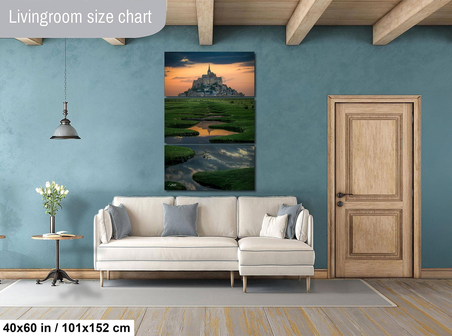 The image is a living room with a large white sofa, a wooden door, and a painting of a castle in the background.