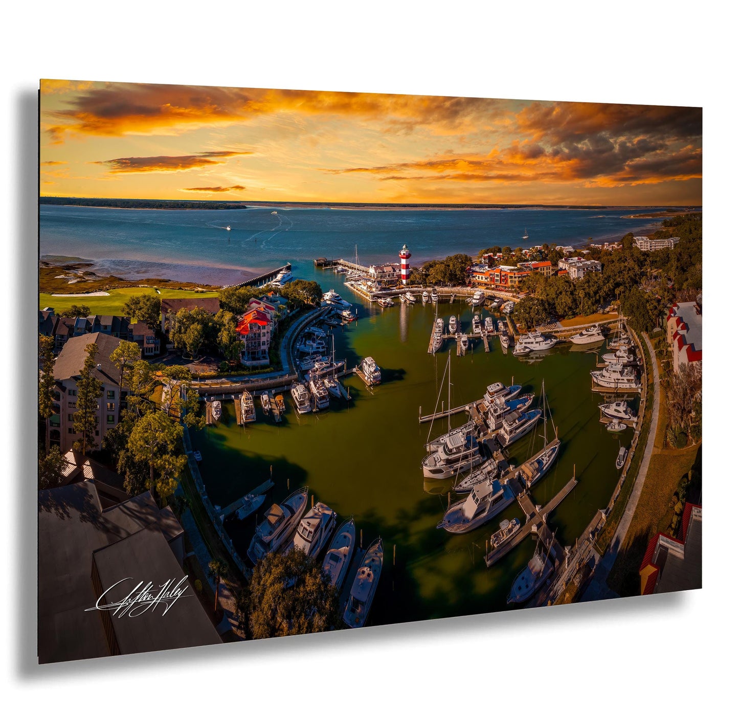 a picturesque harbor scene with a variety of boats docked in the calm waters, surrounded by lush greenery and buildings. The sky is filled with vibrant colors, suggesting a beautiful sunset or sunrise. The image is a collage of multiple images, showcasing the serene atmosphere and the stunning view of the harbor.