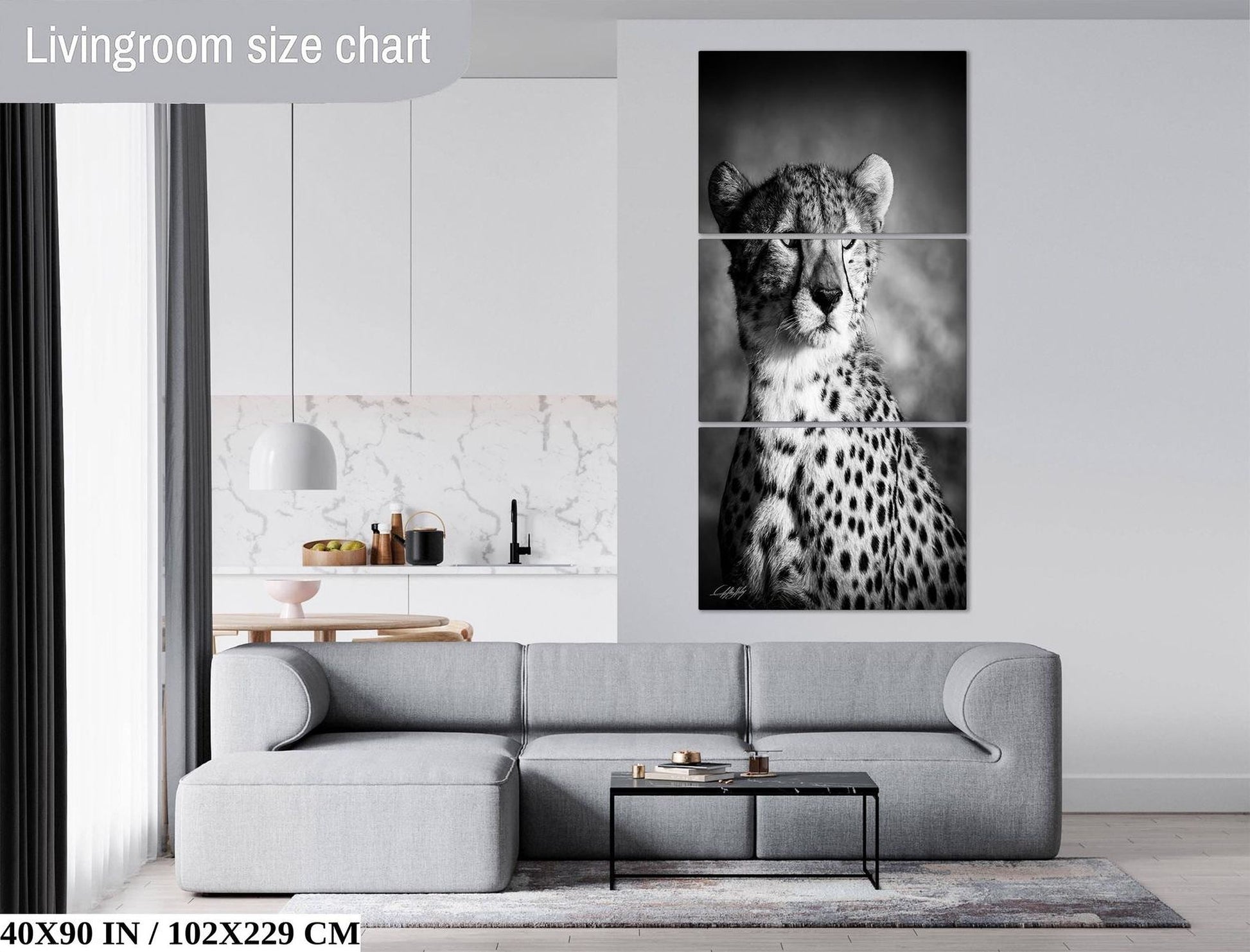 The image is a living room with a gray sofa, a coffee table, and a large black and white photograph of a cheetah on the wall.