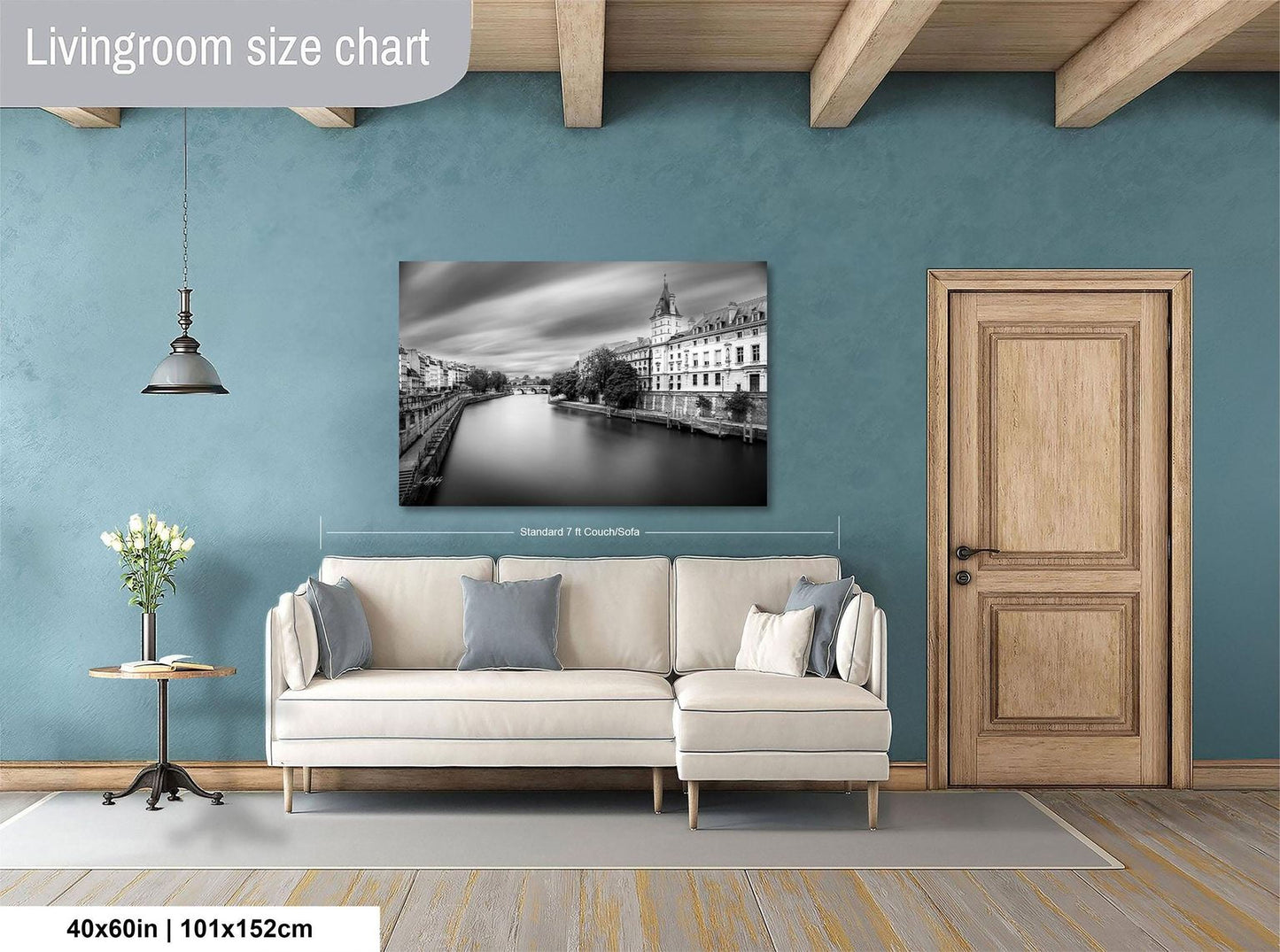 a living room with a large white sofa, a wooden door, and a framed black and white photograph of a cityscape hanging on the wall.