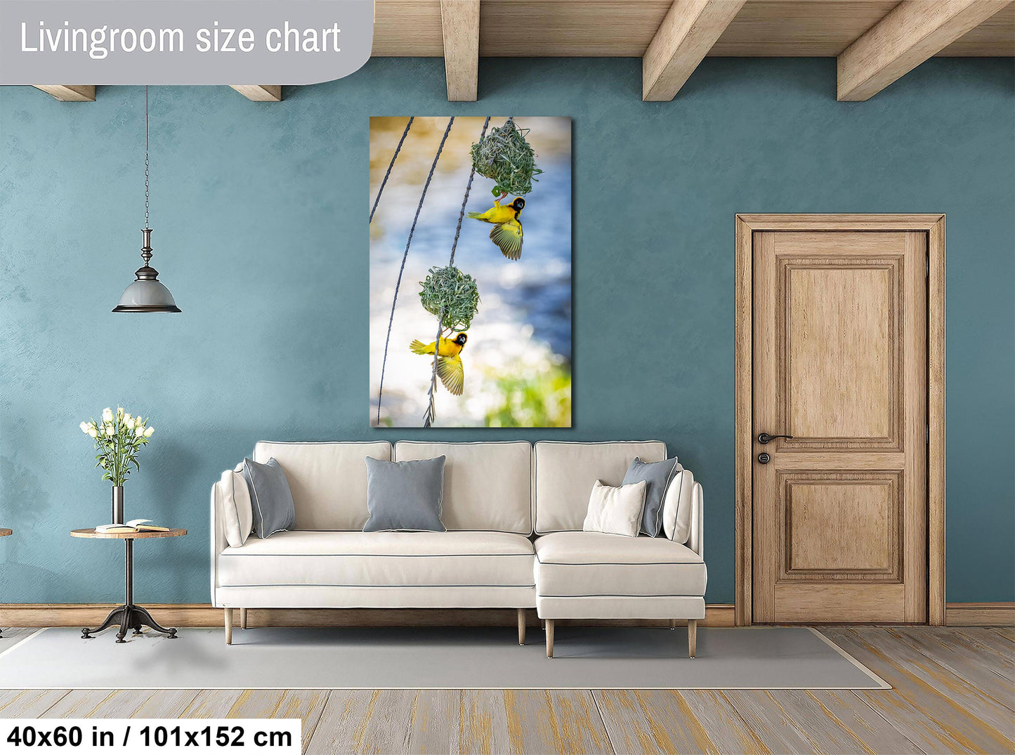 a living room with a white sofa, a wooden door, and a large painting of birds hanging from a wire.