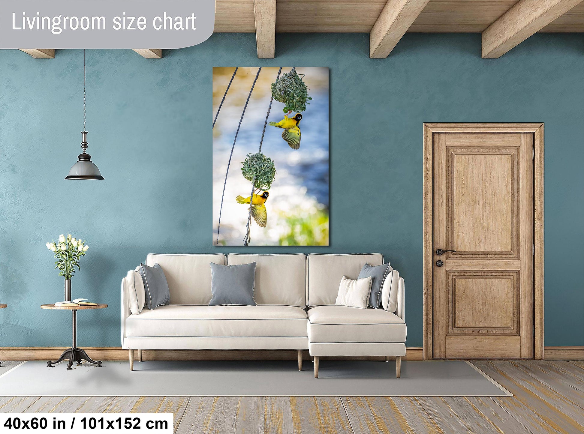 a living room with a white sofa, a wooden door, and a large painting of birds hanging from a wire.