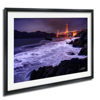 a stunning nighttime view of the Golden Gate Bridge, with its iconic towers illuminated against a dark sky. The bridge is seen from the water, creating a captivating contrast between the man-made structure and the natural beauty of the surrounding landscape.