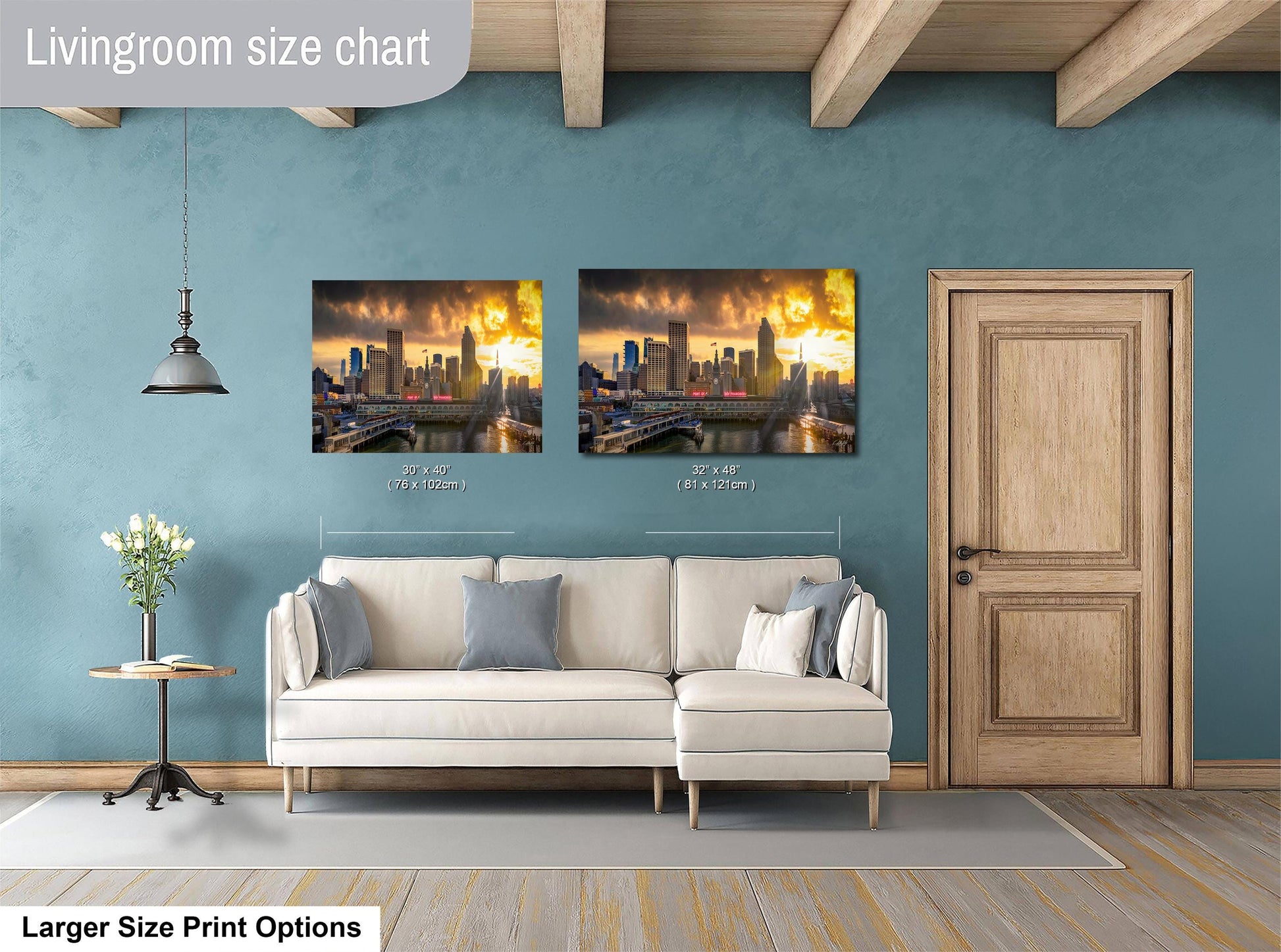 a living room with a white sofa and a wooden door. Above the sofa, there are two framed photographs of a city skyline at sunset, with the size of the photographs indicated as 30x60 inches and 31x42 inches.