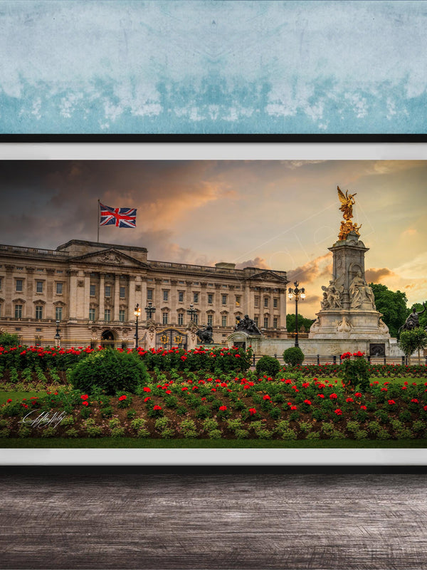 A framed photograph of the Palace of Westminster in London, England, with the British flag flying above the building and a statue in the foreground.