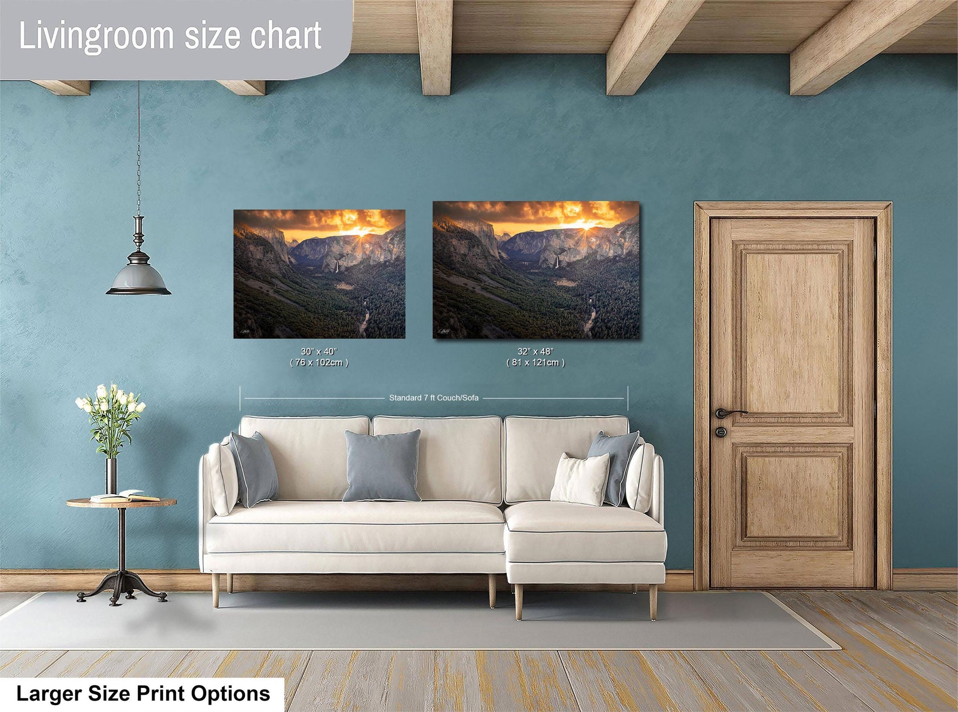 a living room with a white sofa, a wooden door, and two framed landscape paintings hanging on the wall.