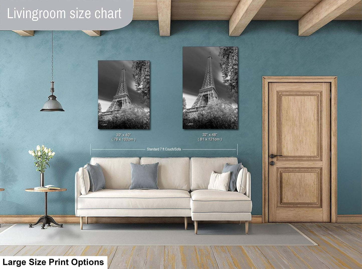a living room with a white sofa, a wooden door, and a framed photograph of the Eiffel Tower on the wall.