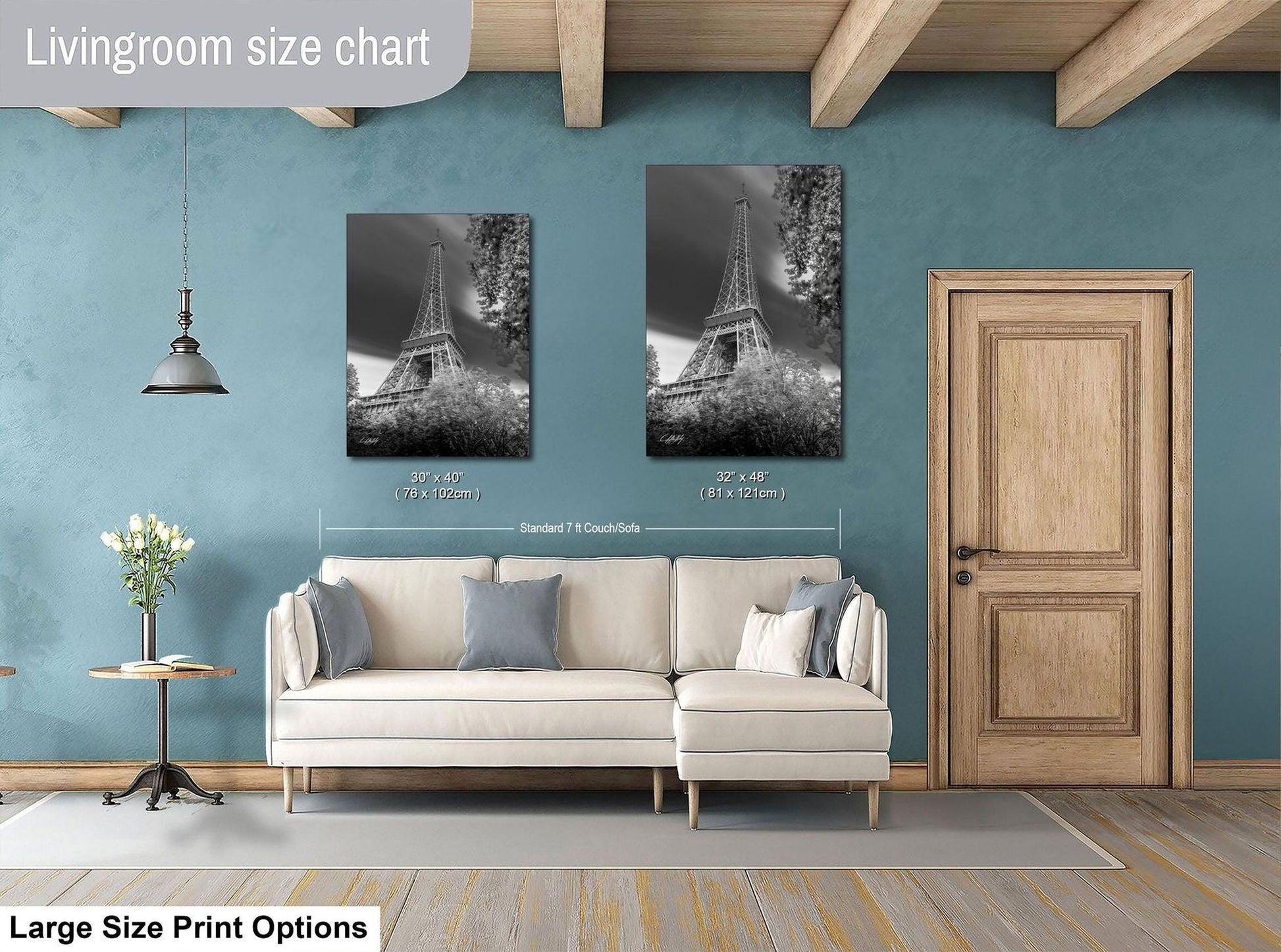 a living room with a white sofa, a wooden door, and a framed photograph of the Eiffel Tower on the wall.