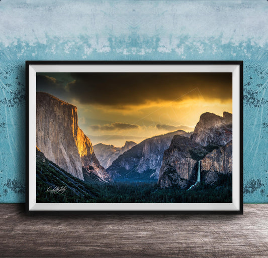 The image is a framed photograph of a breathtaking mountainous landscape at sunset, with dramatic clouds and a waterfall in the foreground.