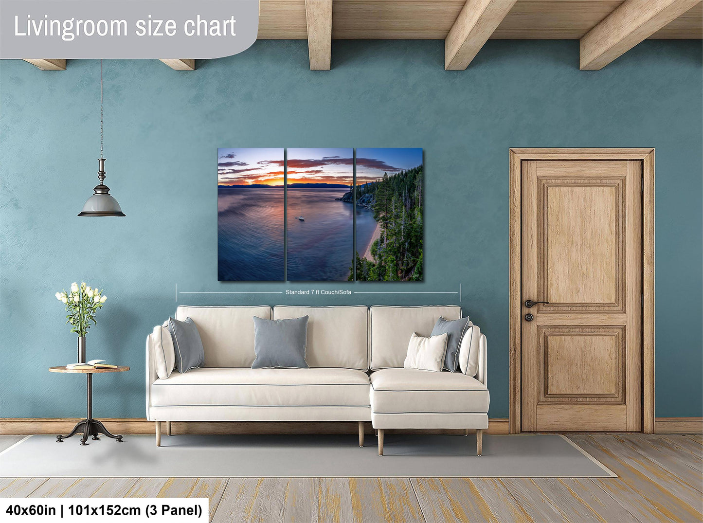 The image is a living room with a large, three-panel landscape painting hanging on the wall. The painting depicts a serene sunset over a body of water, with a boat visible in the distance. The room has a white sofa and a wooden door, creating a cozy and inviting atmosphere.