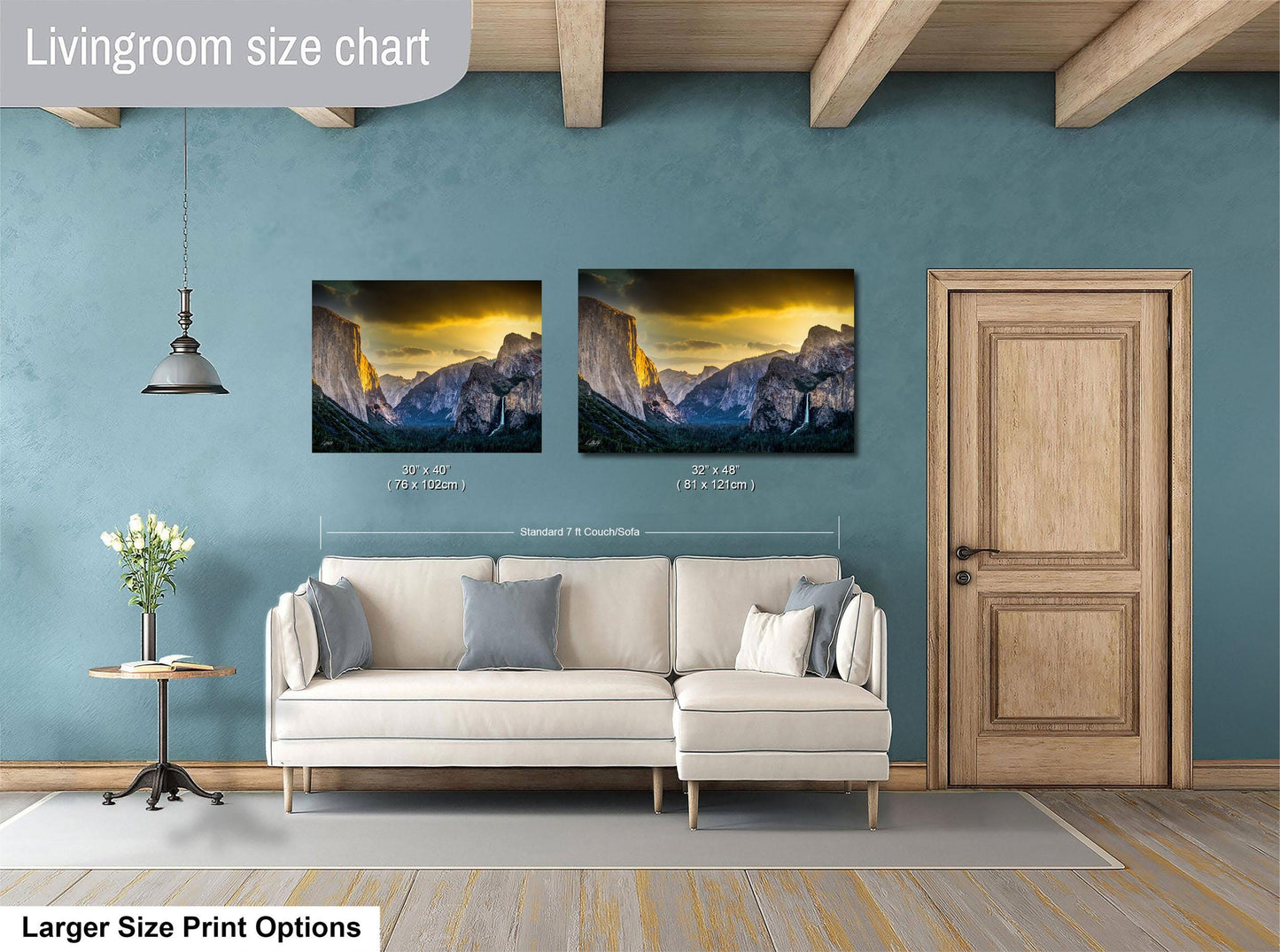 a living room with a white sofa and a wooden door. Above the sofa, there are two framed pictures of a mountainous landscape, likely depicting the Grand Canyon. The living room has a blue wall and a wooden ceiling, creating a cozy and inviting atmosphere.
