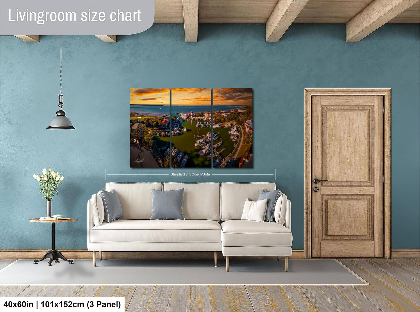 The image is a living room with a large, colorful, and detailed painting of a cityscape hanging on the wall. The painting is divided into three panels, and the living room has a white sofa, a wooden door, and a small table with a vase of flowers.