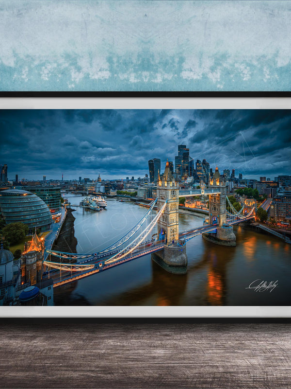 A framed photograph of the London skyline at night, featuring the iconic Tower Bridge and the River Thames.