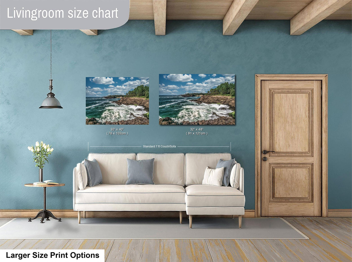 a living room with a white sofa and a wooden door. Above the sofa, there are two framed pictures of a coastal landscape, depicting a rocky shoreline with crashing waves. The living room has a blue wall and a wooden ceiling, creating a cozy and inviting atmosphere.