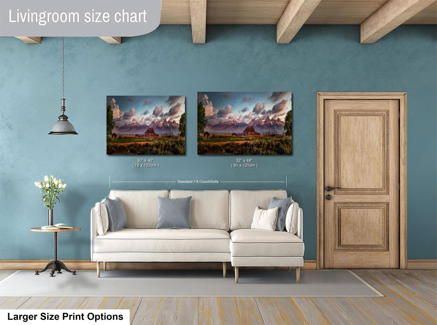 a living room with a white sofa and a wooden door. Above the sofa, there are two framed landscape paintings hanging on the wall. The paintings depict a scenic mountain landscape. The living room has a blue wall and a wooden ceiling.