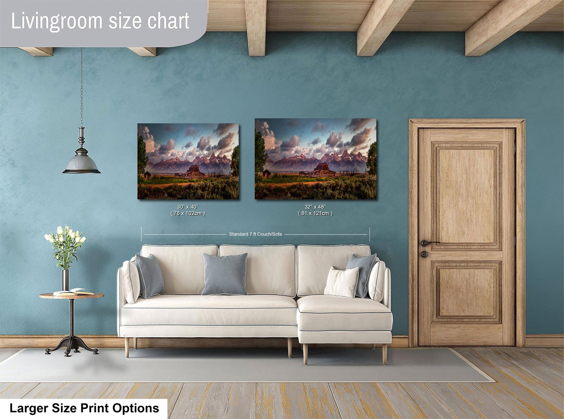a living room with a white sofa and a wooden door. Above the sofa, there are two framed landscape paintings hanging on the wall. The paintings depict a scenic mountain landscape. The living room has a blue wall and a wooden ceiling.