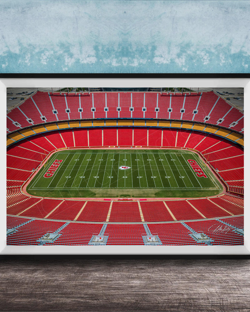 The image is a framed photograph of a football stadium, specifically the Kansas City Chiefs stadium, with a focus on the field and seating areas.