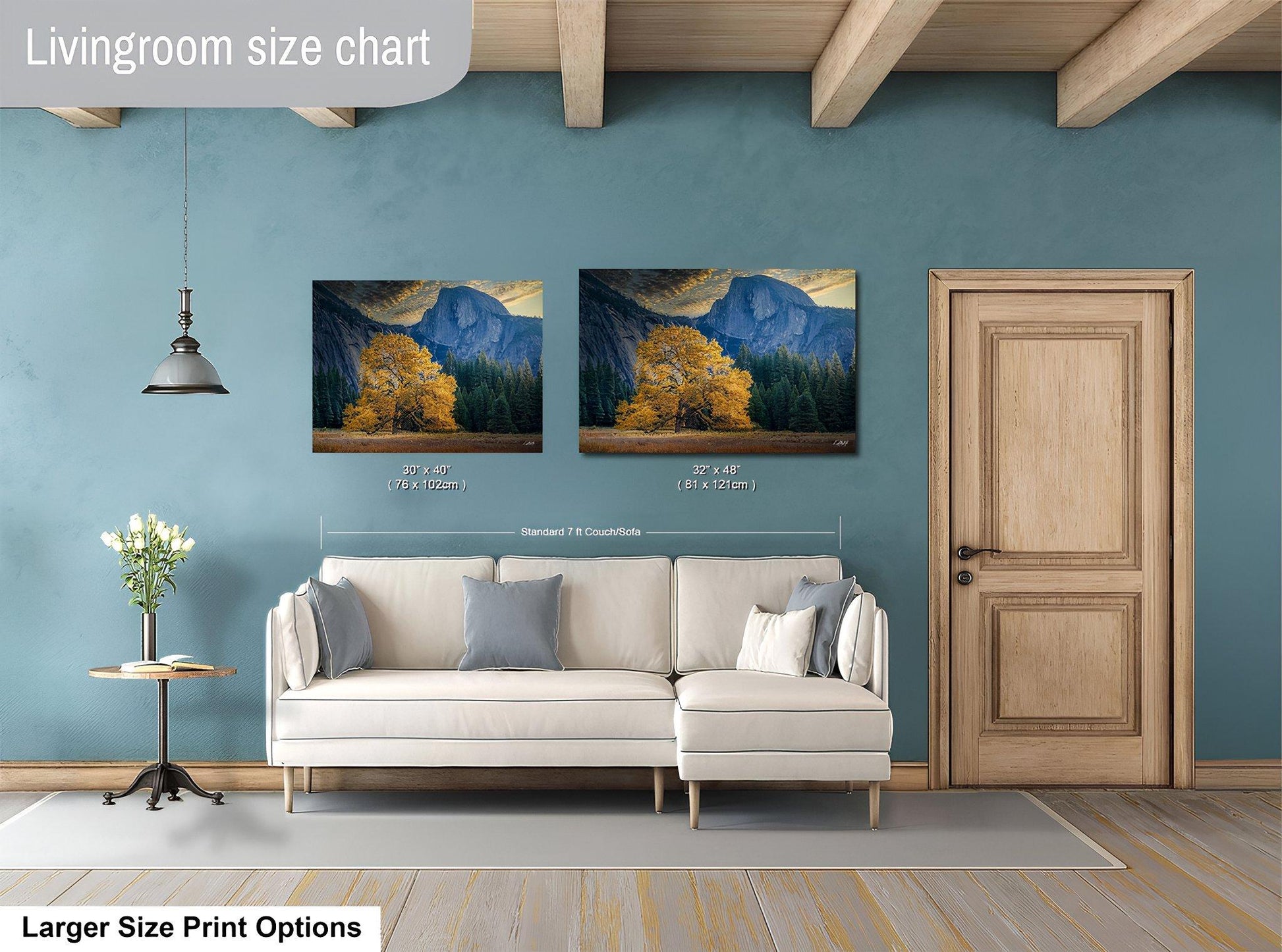 a living room with a white sofa, a wooden door, and two framed landscape paintings hanging on the wall.