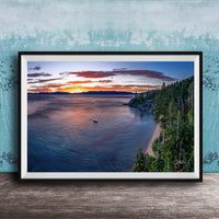 A framed photograph depicting a serene landscape with a calm lake, a boat on the water, and a forested shoreline in the background.