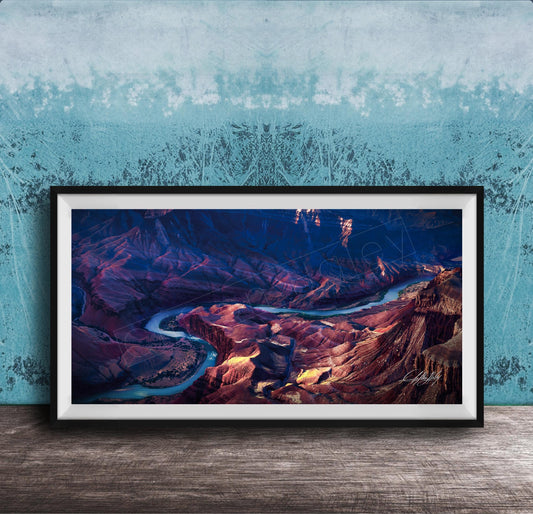 The image is a framed photograph of a breathtaking natural landscape, featuring a winding river surrounded by rugged mountains and valleys.
