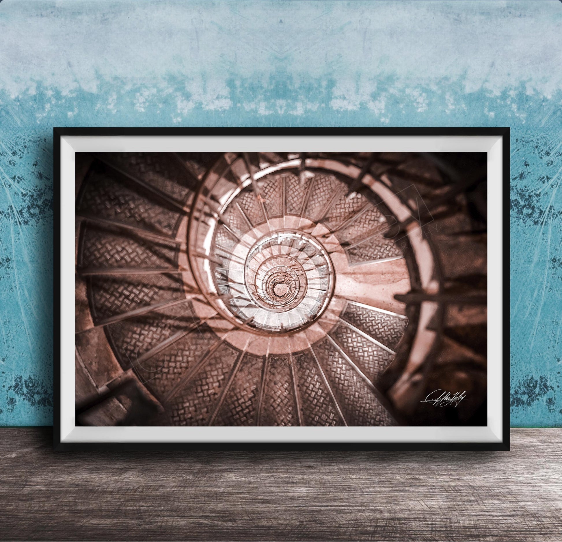 The image is a framed photograph of a spiral staircase, with the steps arranged in a spiral pattern and the image captured from a low angle.