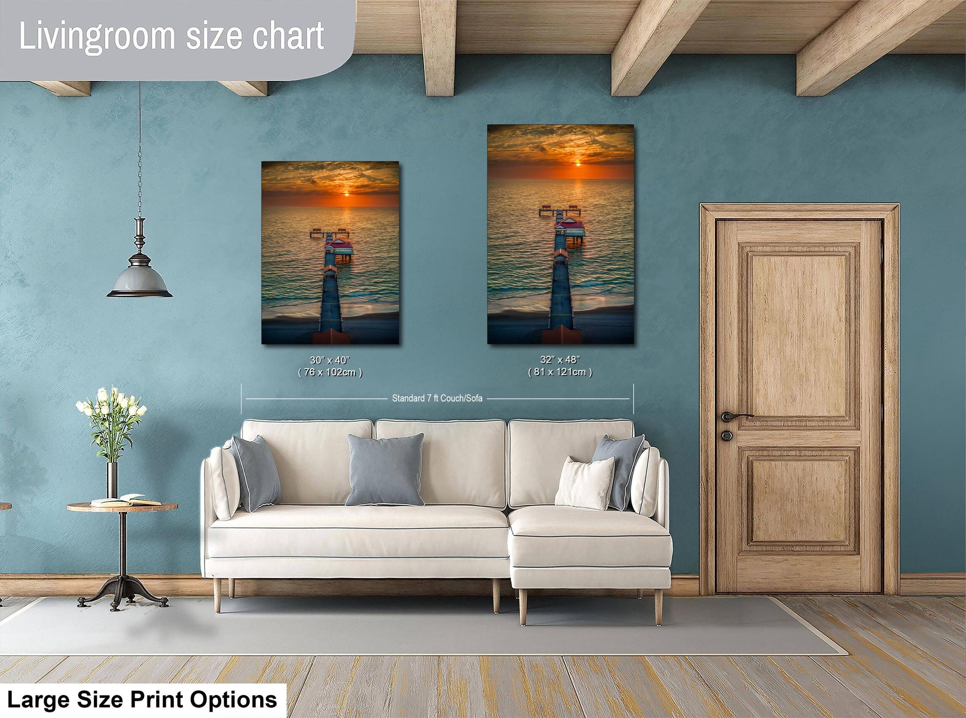 a living room with a white sofa, a wooden door, and two framed pictures of a sunset on the wall.