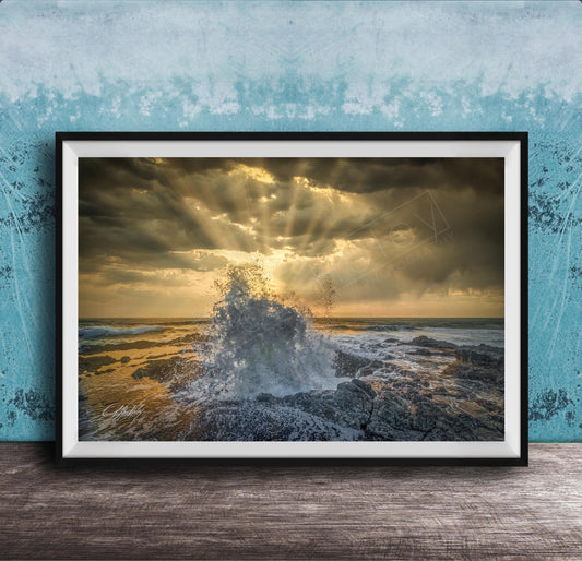 The image is a framed photograph of a dramatic ocean scene, with crashing waves and a dramatic sky filled with clouds and sunbeams.