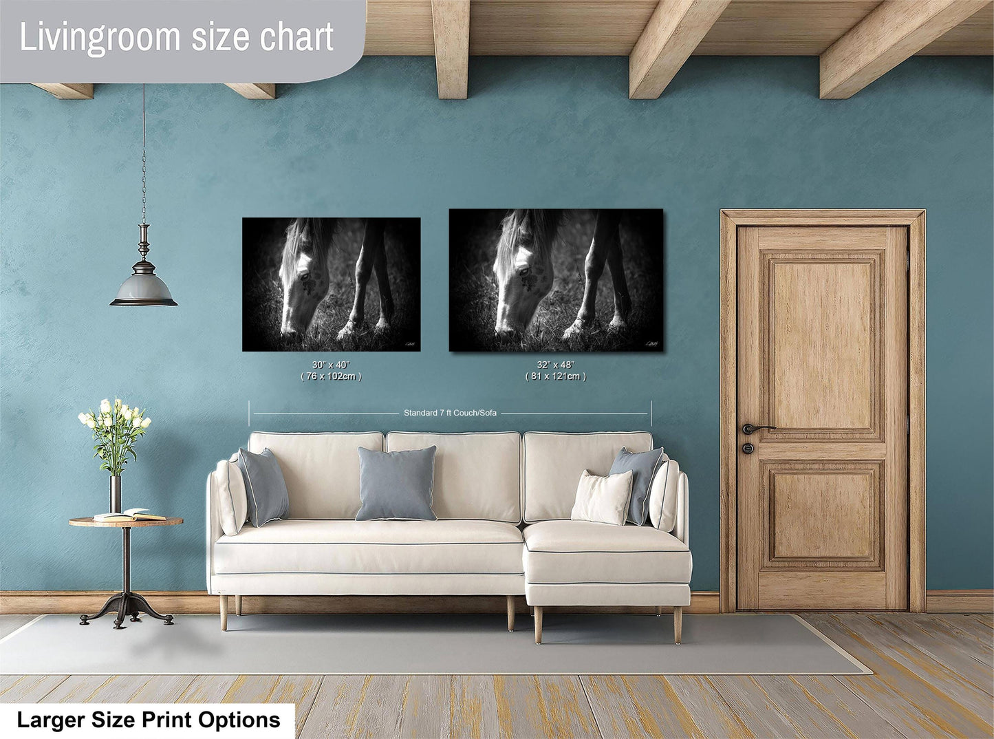 a living room with a white sofa, a wooden door, and two black and white photographs of horses on the wall.