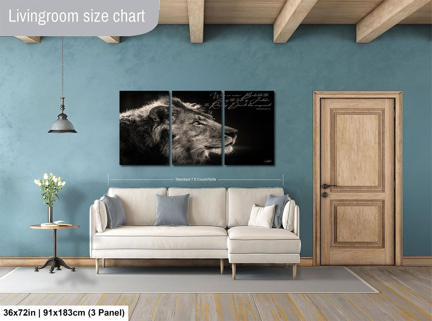 The image is a living room with a large wall art depicting a lion's head. The wall art is divided into three panels, with the largest panel being the central focus. The room has a white sofa, a wooden door, and a small table with a vase of flowers. The wall art is approximately 36 inches wide and 11 inches tall, and it is mounted on a blue wall.