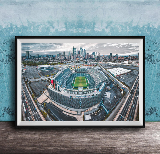 An aerial view of a large sports stadium surrounded by a city skyline, with the stadium's field and surrounding parking lots visible.