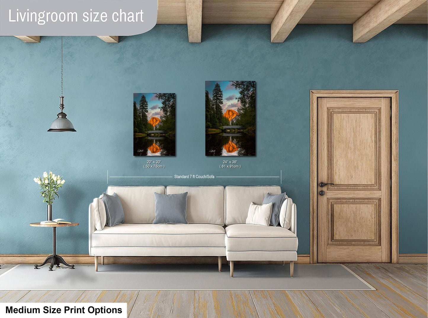 a living room with a white sofa, a wooden door, and a painting of a sunset over a lake on the wall.