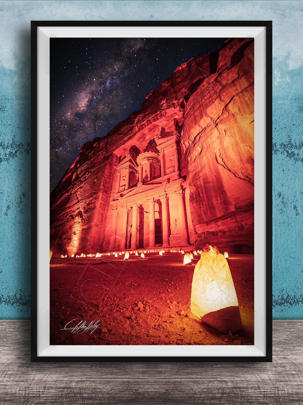 a large, illuminated building with a red and orange glow, set against a night sky with stars.