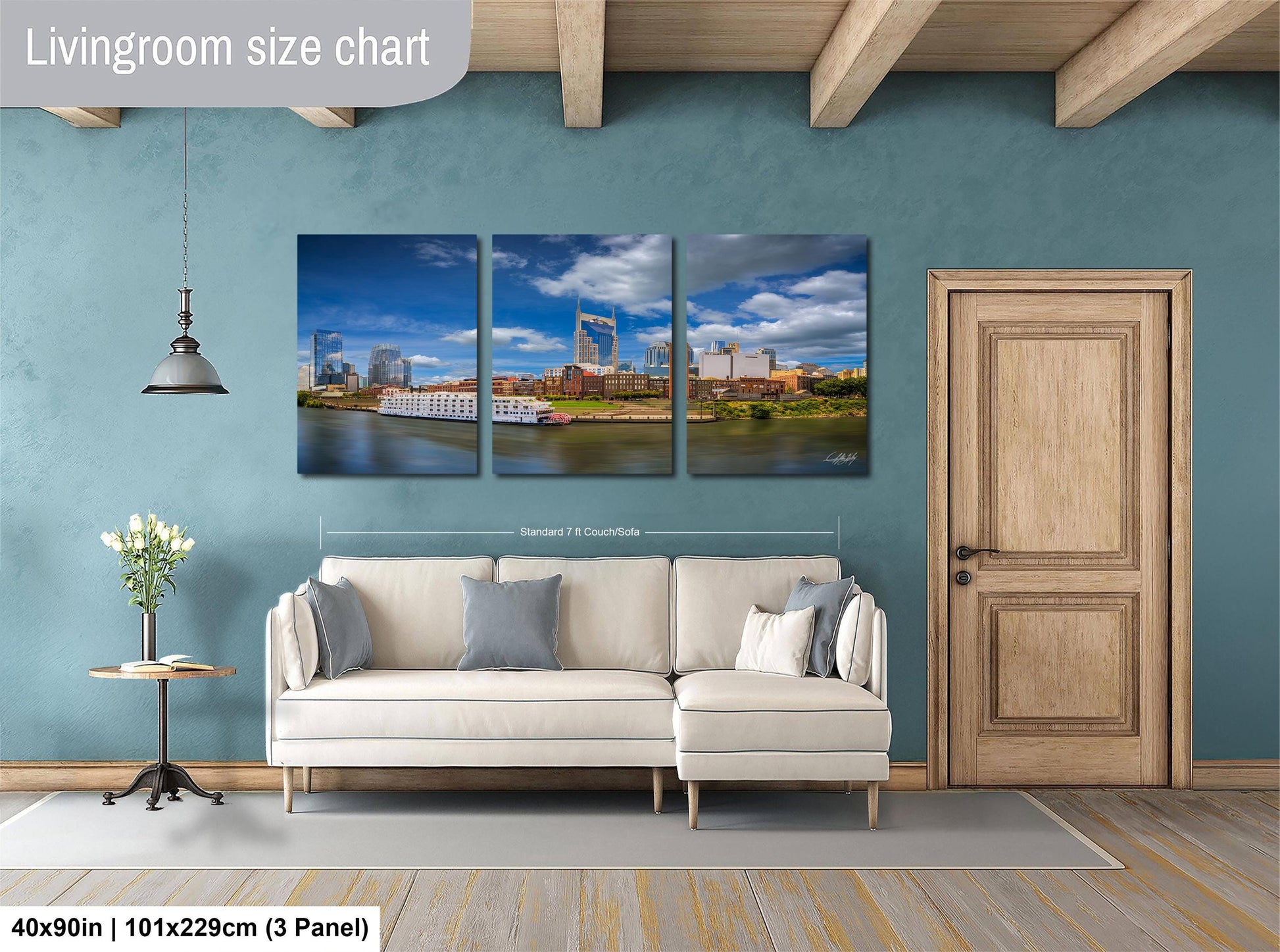 The image is a living room with a large, three-panel living room size chart on the wall. The chart displays the dimensions of the living room in feet and inches, with the largest panel being 40'x50'', followed by a smaller panel of 51'x29'', and the smallest panel of 3'x3''. The living room is furnished with a white sofa and a wooden door, and there is a vase of flowers on a table nearby.