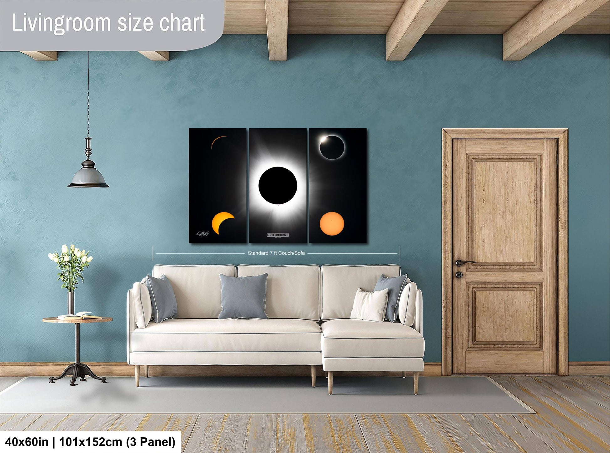 The image is a living room with a white sofa, a wooden door, and a large wall art depicting the solar eclipse. The living room has a blue wall and a wooden floor.