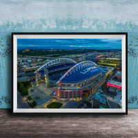 a large stadium with a curved roof, surrounded by a cityscape at night.