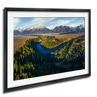 a serene landscape with a winding river surrounded by lush green forests and majestic snow-capped mountains in the background.