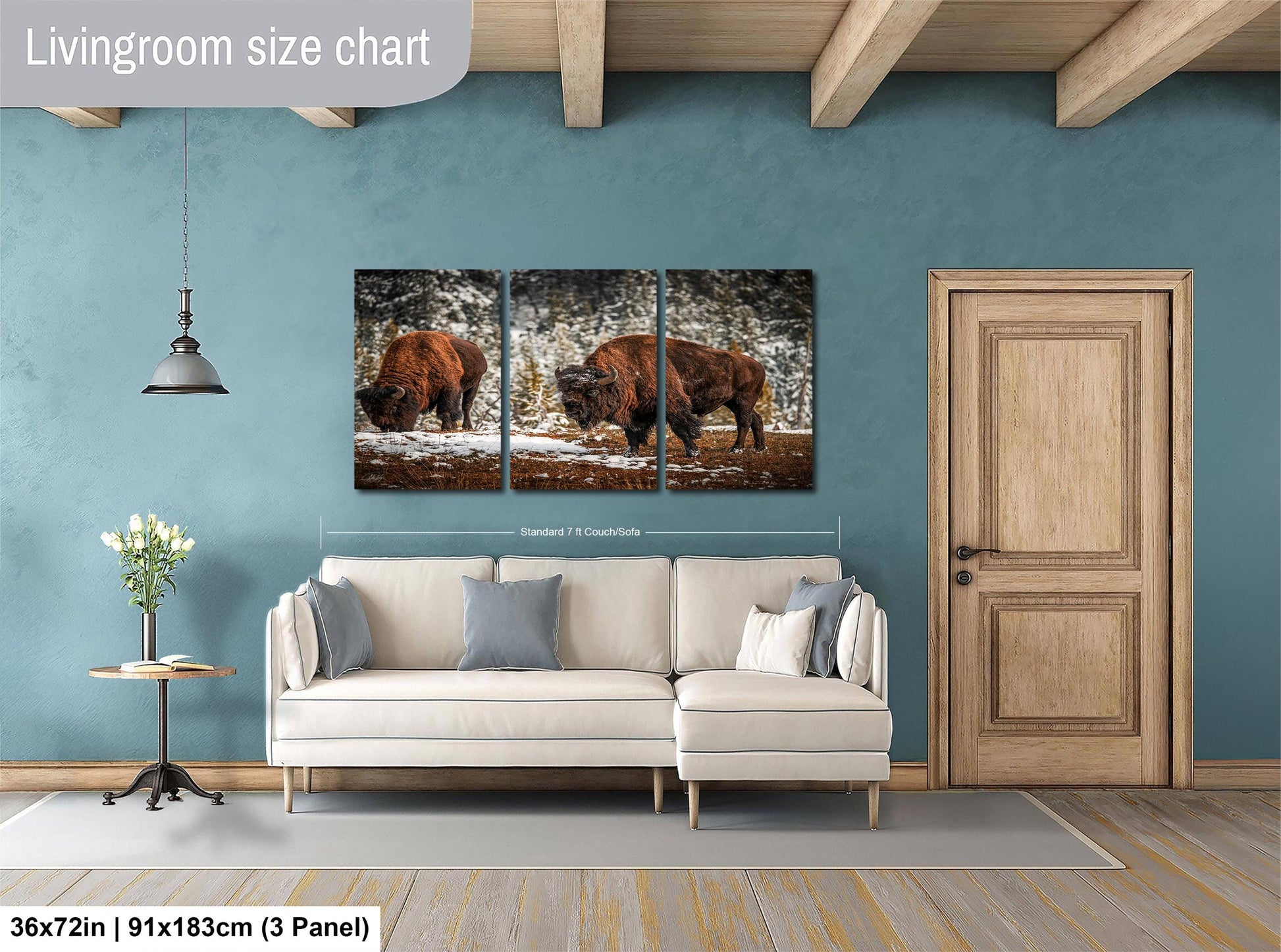The image is a living room with a large painting of two bison in a snowy field hanging on the wall. The painting is divided into three panels, and the living room has a white sofa and a wooden door.