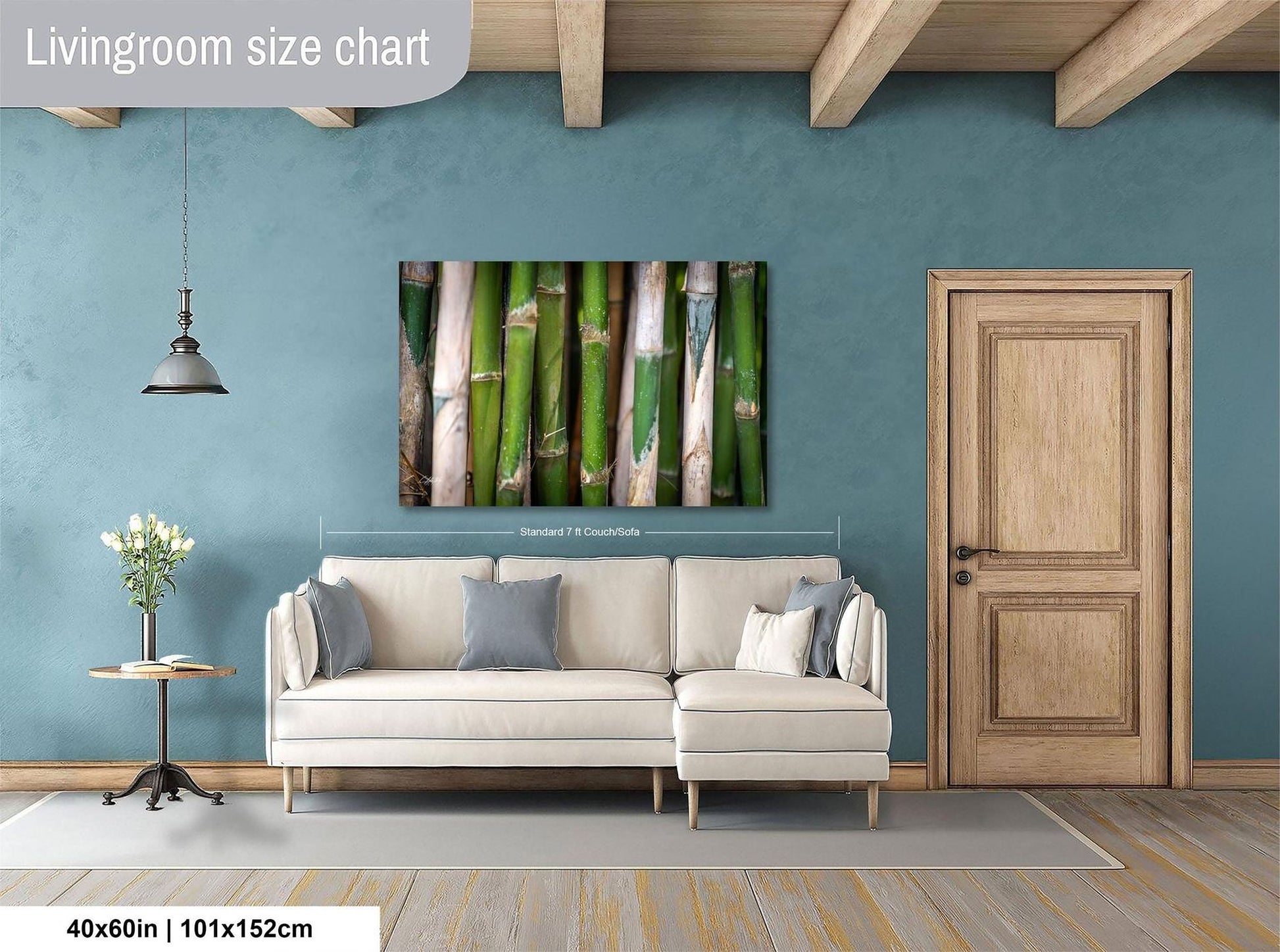 a living room with a white sofa, a wooden door, and a painting of bamboo on the wall.