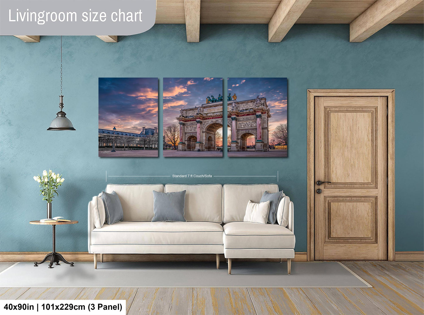 The image is a living room with a large wall art piece depicting the Arc de Triomphe in Paris, France. The wall art is divided into three panels, each showing different angles of the iconic monument. The living room has a white sofa and a wooden door, creating a cozy and inviting atmosphere.